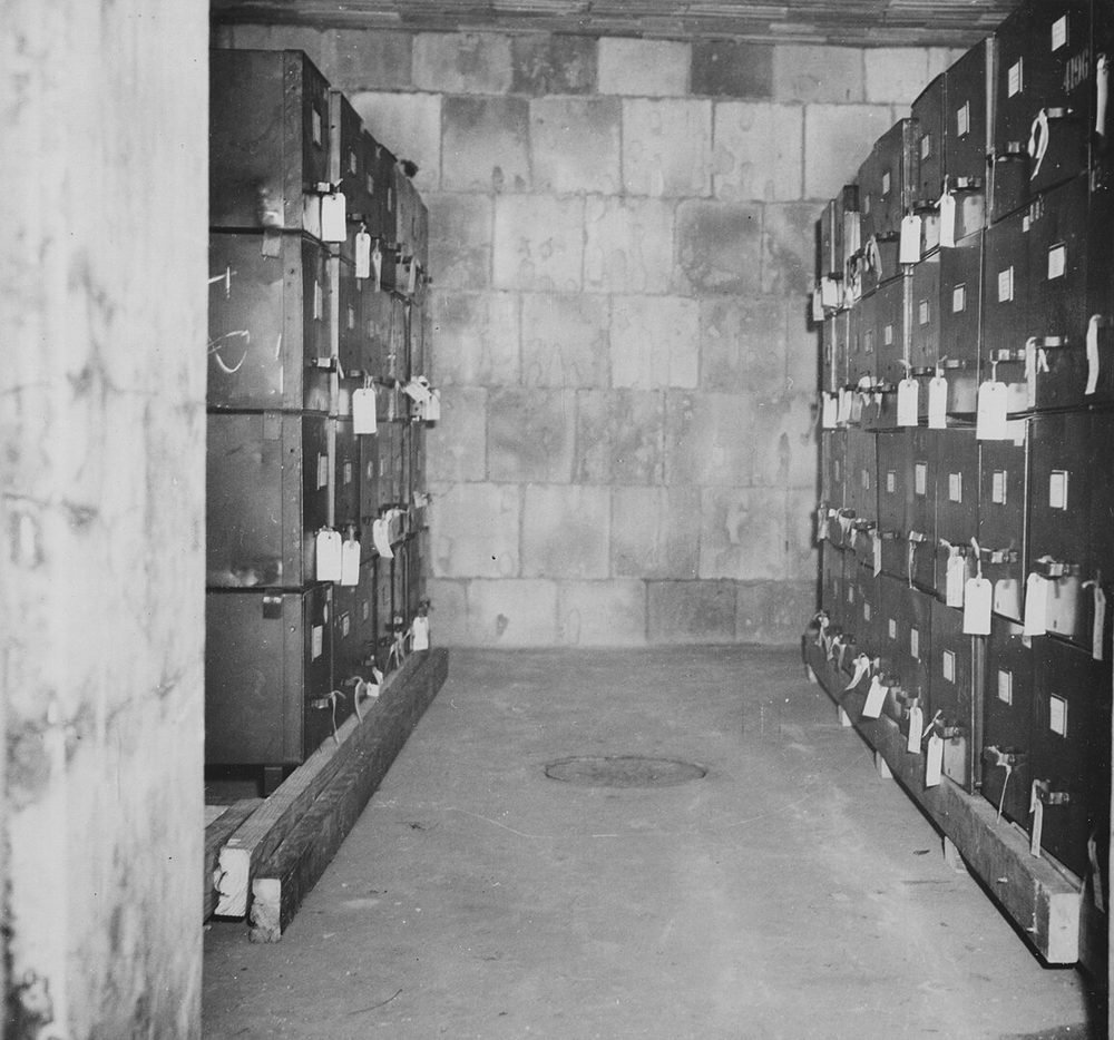 A concrete room inside a gun battery lined with rows of labeled metal storage cabinets.